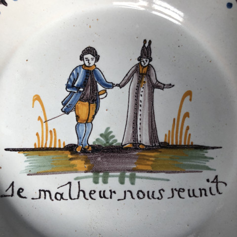 Assiette à décor d’un curé tenant la main à un noble - Manufacture Nevers