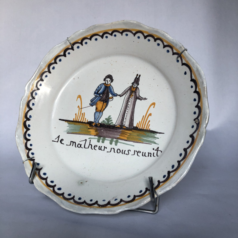 Assiette à décor d’un curé tenant la main à un noble - Manufacture Nevers