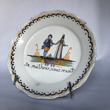 Assiette à décor d’un curé tenant la main à un noble - Manufacture Nevers